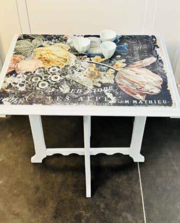 Ontdek deze midcentury bijzettafel met een uniek design. Zacht groen, bloemen-decoupage en unieke poten. Tijdloos design en vintage charme.
