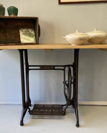 Sidetable op gietijzeren onderstel. Sidetable van massief eiken blad op gietijzeren onderstel. Het onderstel van een oude Singer trapnaaimachine.
