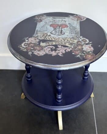 Ontdek de unieke ronde bijzettafel Burlesque. Een handgemaakte massief grenen tafel in diep donkerblauw met gouden details en artistieke afwerking.