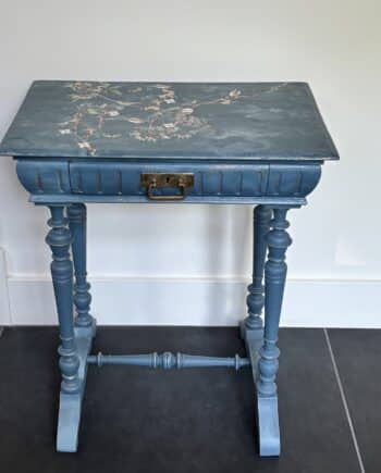 Vintage Deense tabakstafel uit ca. 1920 met lade en vakjes. Geschilderd in zeegroen met vogeltransfer en goudaccenten. Uniek gerestaureerd bijzettafeltje.
