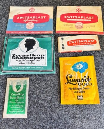 Retro set drogisterijartikelen uit de jaren 40–70 met Zwitsaplast pleisters van Zwitsal, Linusit Gold en Zwartkop sachets. Originele vintage verpakkingen.
