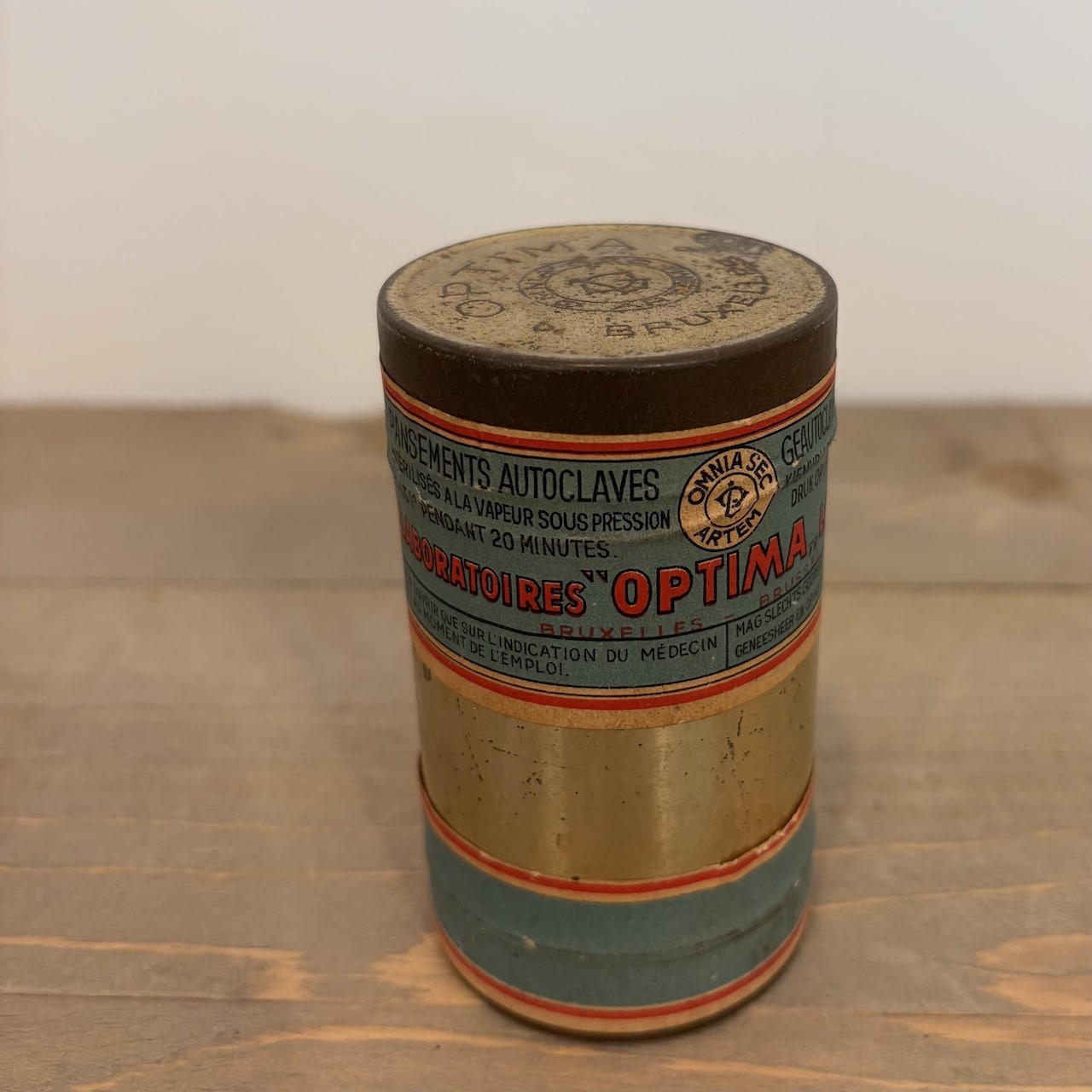 Vintage verbandblikje Optima Bruxelles uit België. Oud metalen apothekersblikje met originele inhoud, vermoedelijk uit de eerste helft van de 20e eeuw.